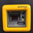 Geld pinnen in de buurt bij de uniforme gele geldautomaat